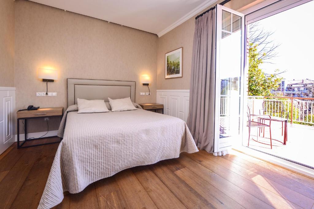 伊伦Hotel Alcazar Irun的一间卧室设有一张床和一个大窗户