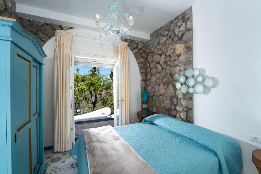 阿纳卡普里Penthouse Donna Carmela的一间卧室设有蓝色的床和窗户。