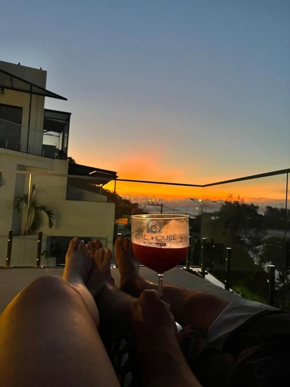 里约热内卢Suítes Luxo Marambaia- Epic House的躺在阳台上喝一杯葡萄酒的人