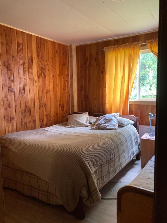 达卡卫Hostal Flor del Meli的一间卧室配有一张带木墙和窗户的床。