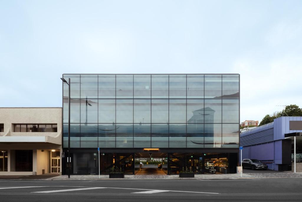 但尼丁Ebb-Dunedin的一座玻璃建筑,上面有一个人的反射