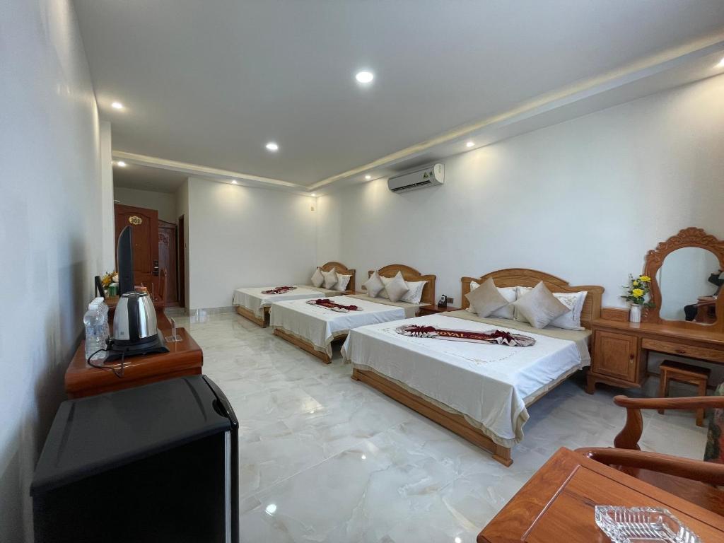 Bạc LiêuRoyal Hotel 2的一间酒店客房,设有两张床和电视