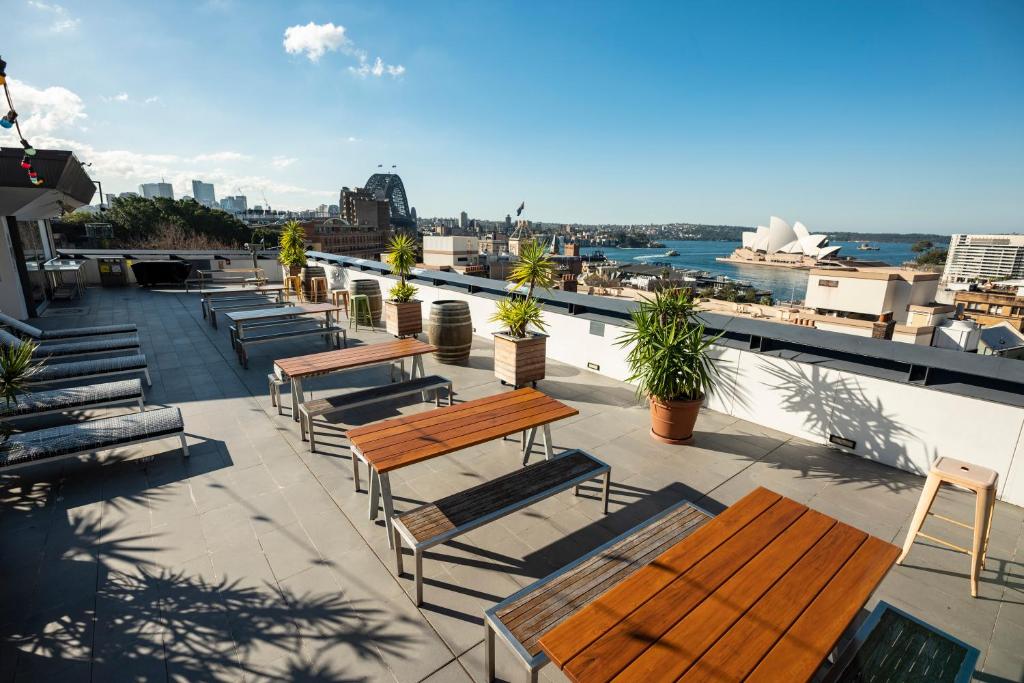 悉尼YHA Sydney Harbour的屋顶上的一组长椅和桌子