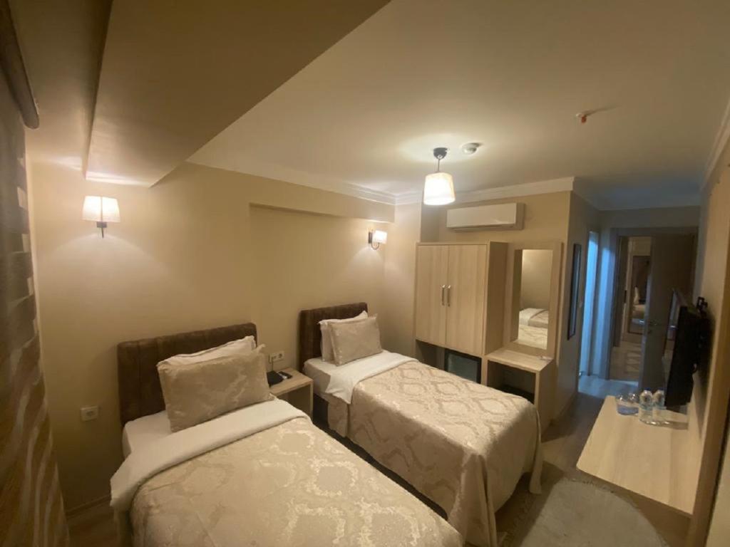 伊斯坦布尔Hotel Mavirem的酒店客房,设有两张床和镜子