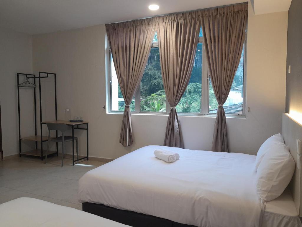 怡保The great的一间卧室设有两张床和窗户。