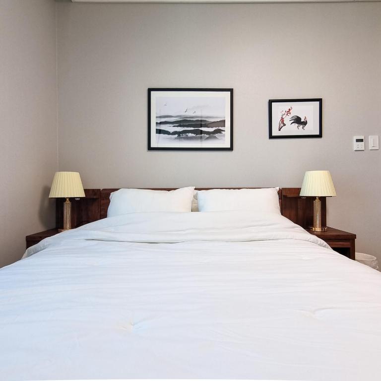 平泽市Humphreys 2 min Vintage Korean Room的一间卧室配有一张带两盏灯的大型白色床。