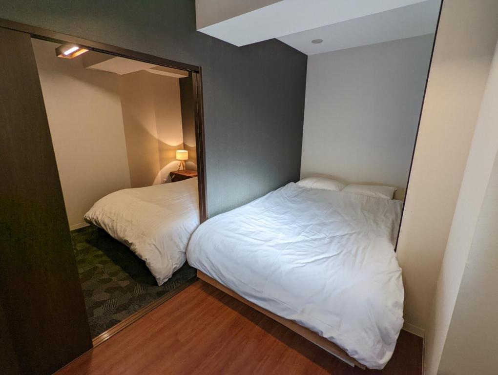 东京Amber Iidabashi的小房间设有两张床和镜子