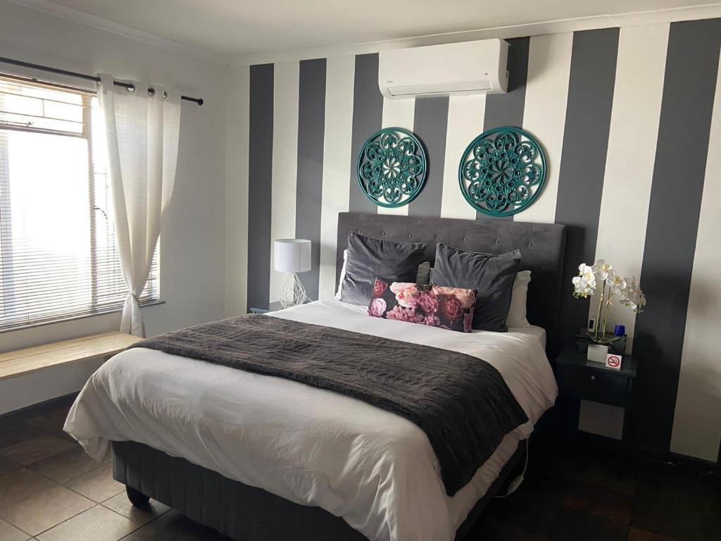 博福特西Karoo Heart的卧室配有一张床和墙上的2个盘子