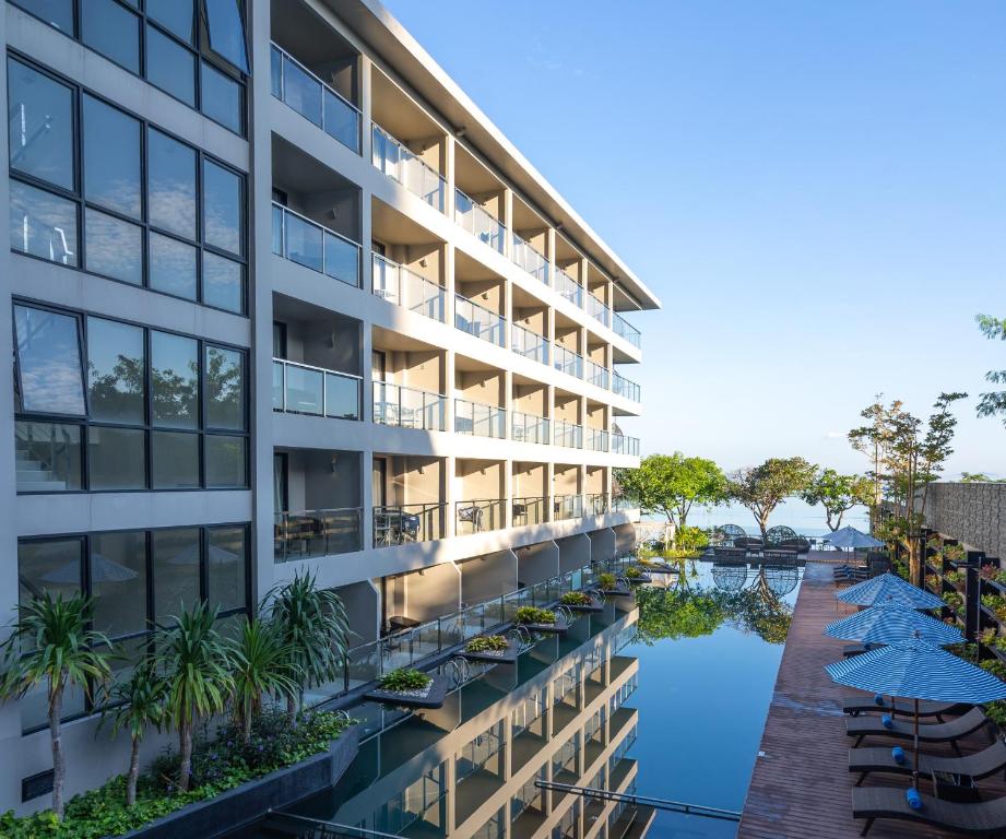 北芭堤雅芭堤雅金色郁金香海滩度假酒店的享有带游泳池和遮阳伞的大楼外部景致