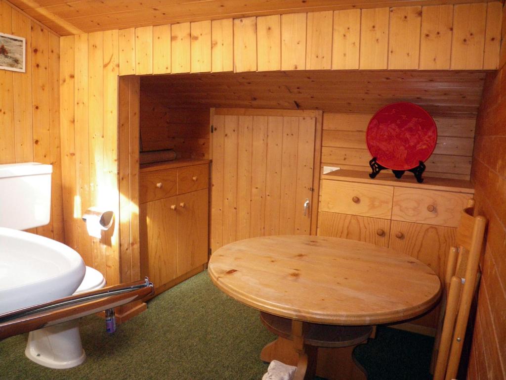 卡雷扎湖Carezza Units, Dolomites的小型木制客房配有桌子和水槽