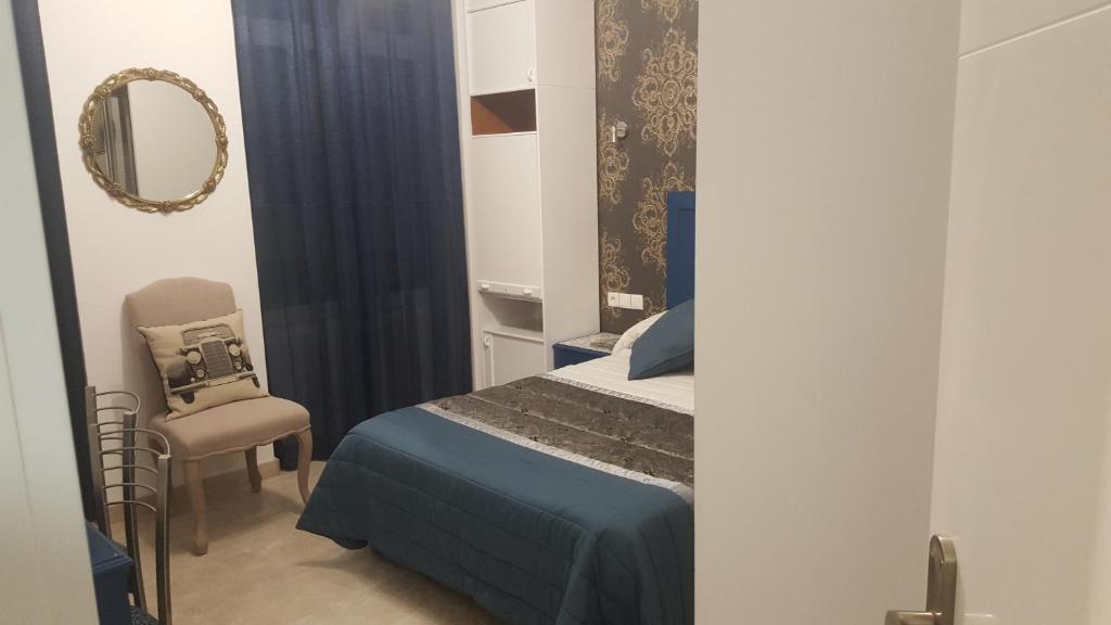 莱昂hospedaje barahona21的一间卧室配有一张床、镜子和椅子