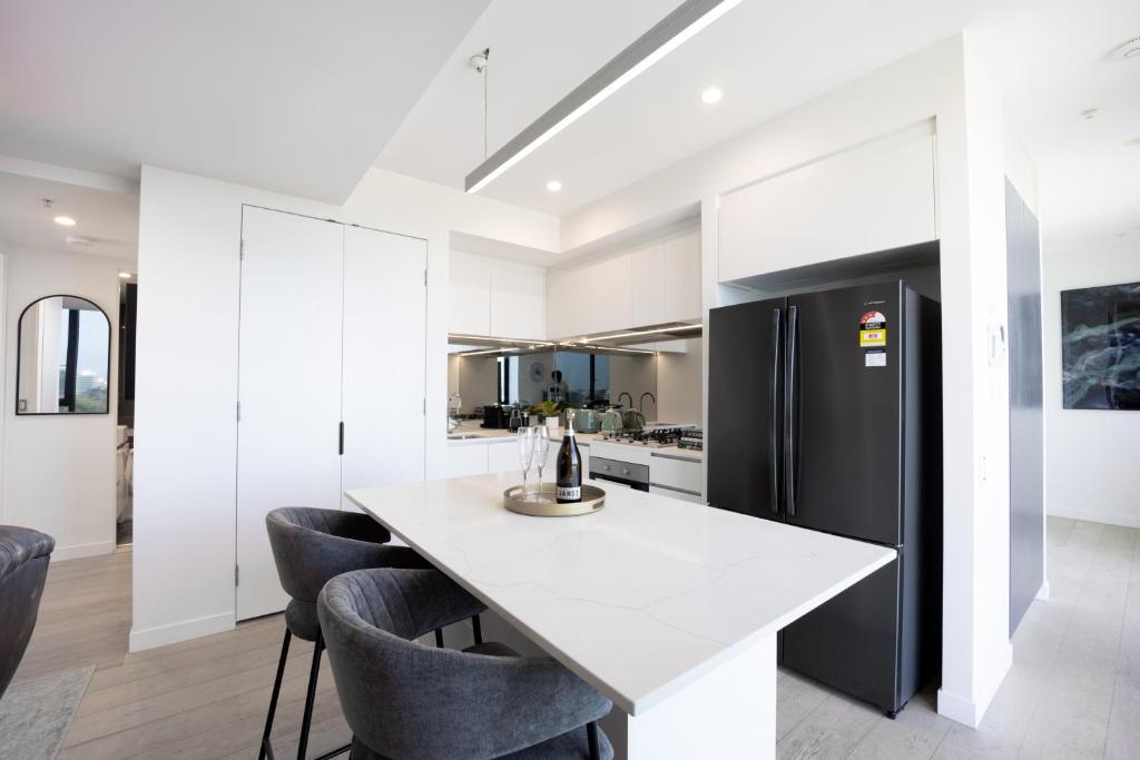 布里斯班Spring Hill - beautiful apartment的厨房配有白色柜台和黑色冰箱。