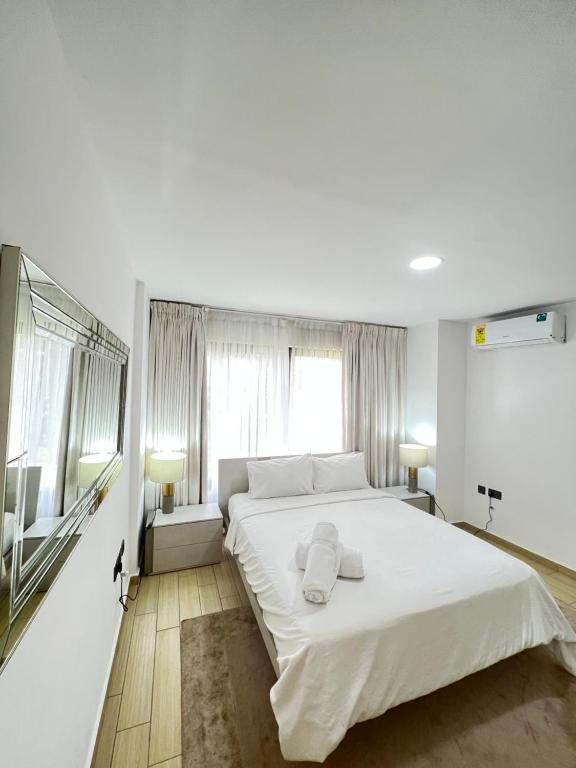 阿克拉Hilton Premium Suite, Labone的卧室配有一张白色大床和两条毛巾