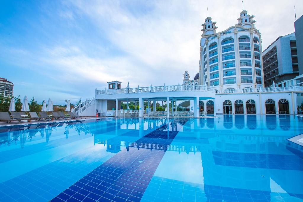 锡德J'adore Deluxe Hotel & Spa Ultra All Inclusive的一座大型游泳池,其建筑背景为: