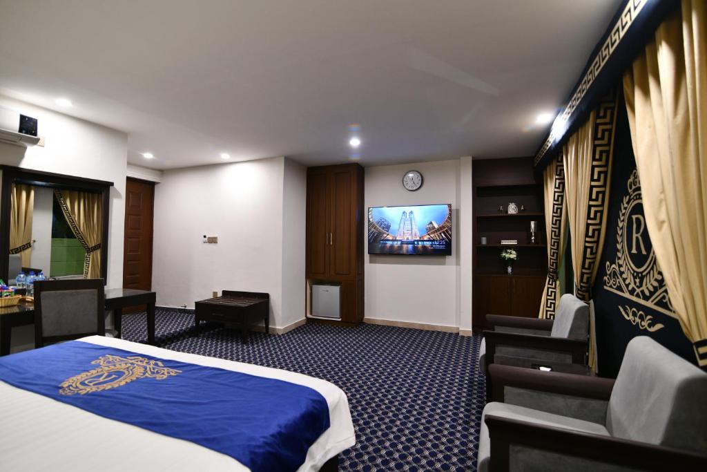 伊斯兰堡Royal Regency Hotel的一间酒店客房,配有一张床和一台电视