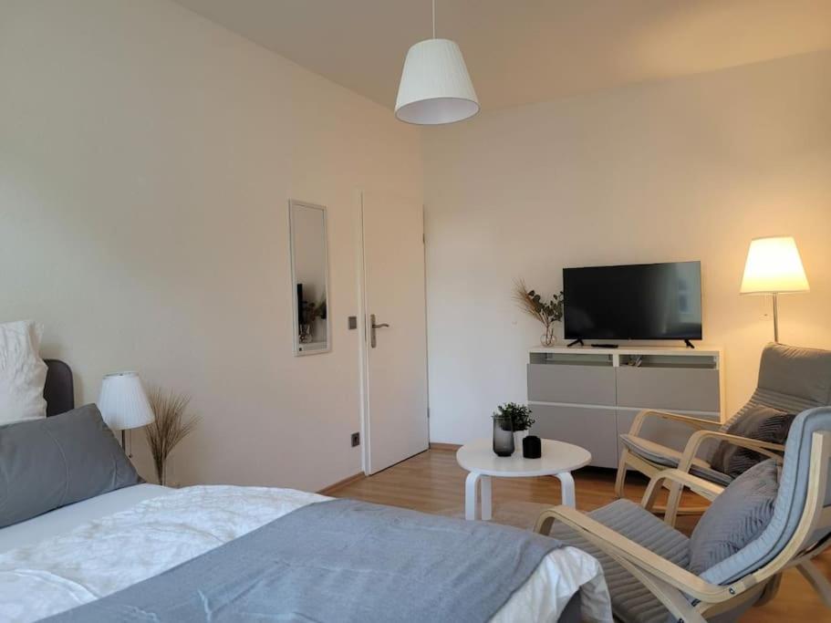 德累斯顿Gemütliches helles Appartement的一间卧室配有一张床铺和椅子以及一台电视。