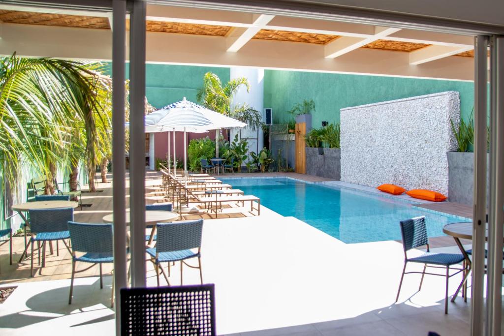 奥林匹亚利里奥阿瓜酒店的一个带椅子和桌子的游泳池以及一把遮阳伞