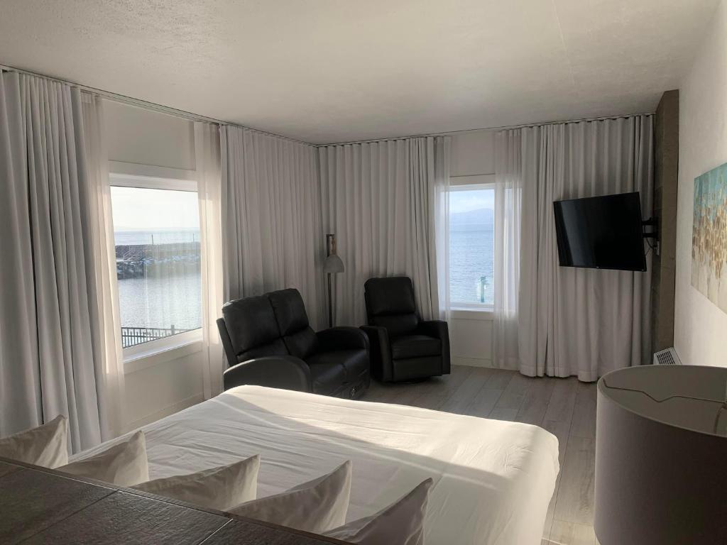 七岛市Hôtel Sept-Îles的酒店客房配有一张床、一把椅子和一台电视。