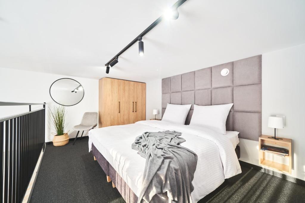 新塔尔格Na Fursie Apartments & Rooms的卧室配有一张大白色的床和大床头板