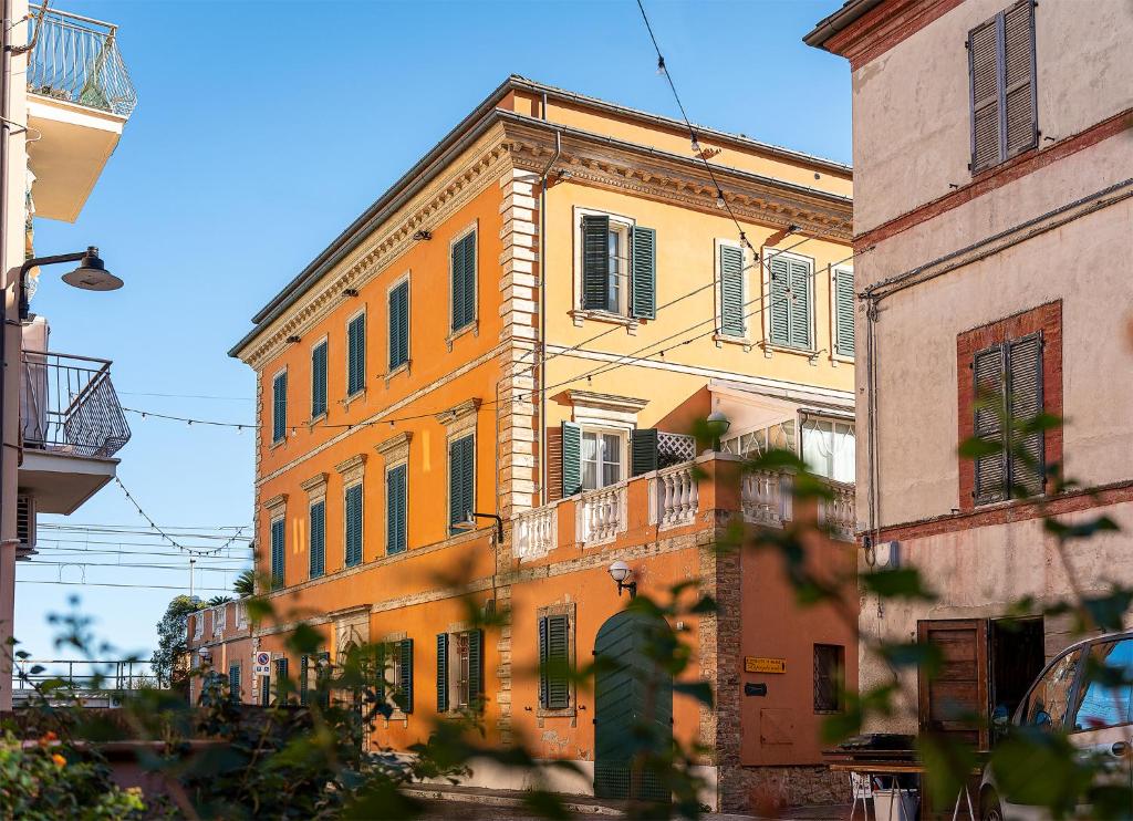 佩达索Dimora Villa Ricci的一条橙色的建筑,在街上有绿色百叶窗