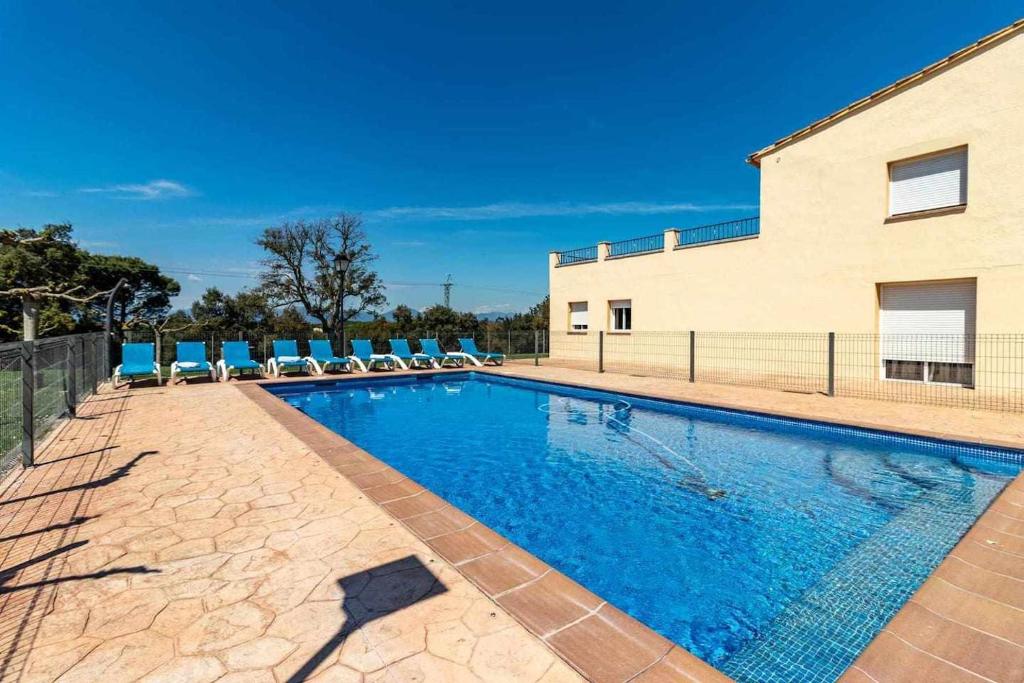 LlambillasCan Bugantó amplia casa con piscina y jardín的一座带椅子的游泳池以及一座建筑