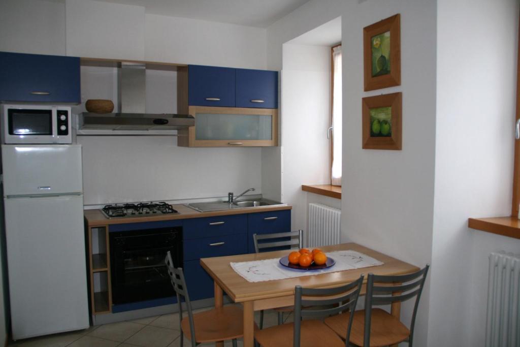 彼得拉穆拉塔Casa Elisa的厨房配有蓝色橱柜和橙色桌子。