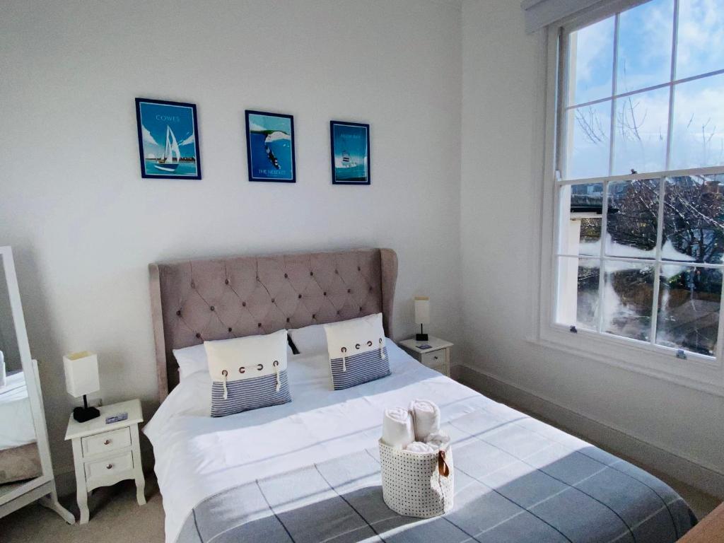 赖德Wight On The Beach, Sleeps 4, Free Off Road Parking, Balcony with Sea Views的一间卧室配有一张带白色床单的床和一扇窗户。