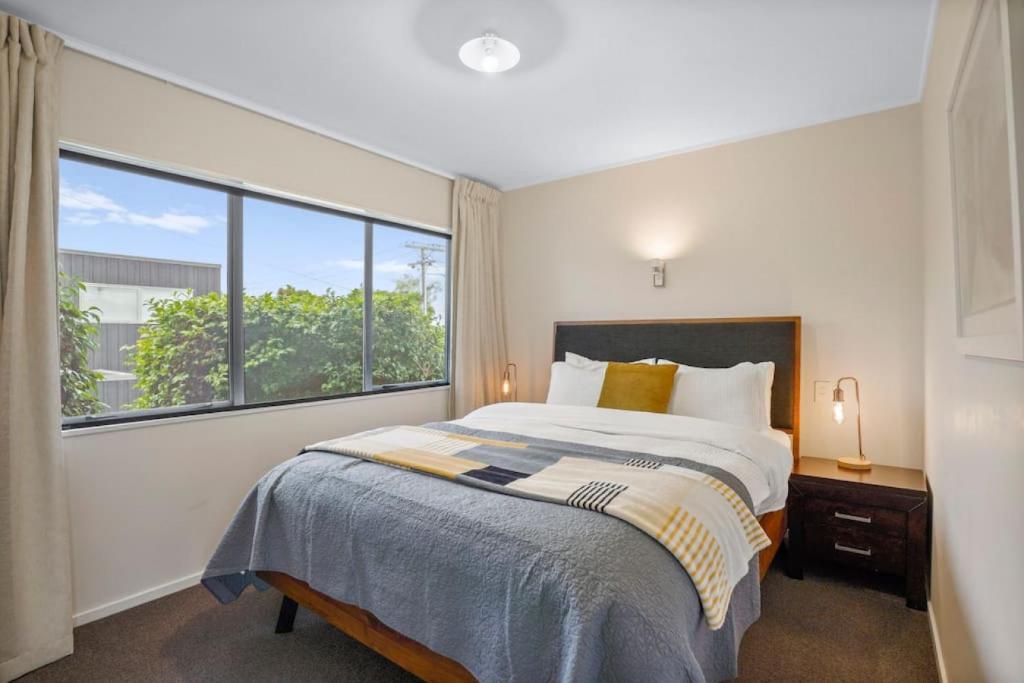 奥克兰Gorgeous 2BR Central Akl Retreat - WI-FI - Netflix的一间卧室设有一张床和一个大窗户