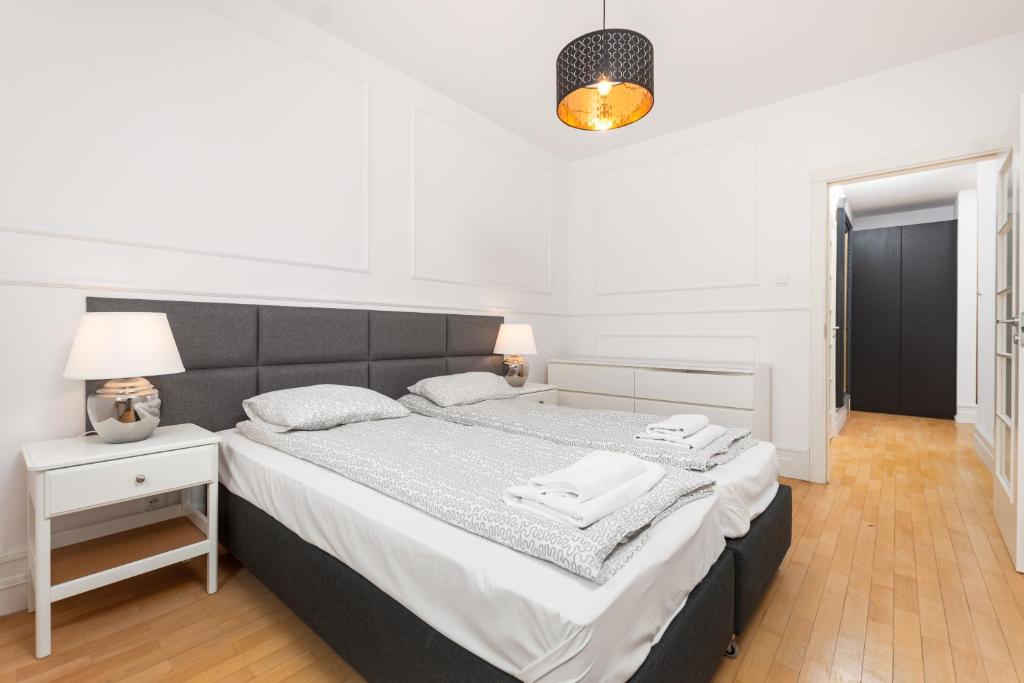 华沙Apartament Polna by Your Freedom的白色卧室设有一张大床和一盏灯。