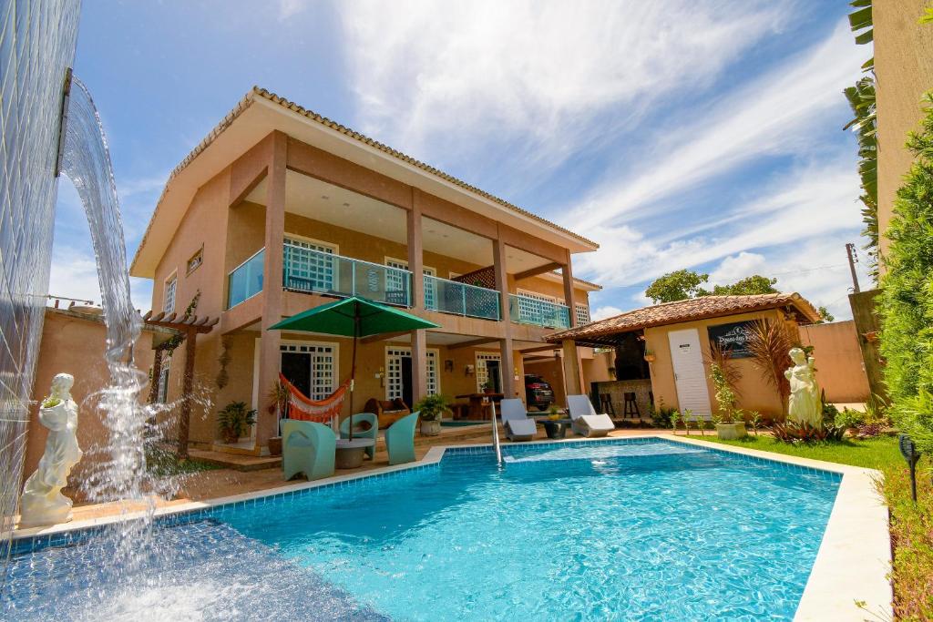马拉戈日Casa de Praia Pouso das Fadas com Arrumadeira e Equipe de Cozinha的一座带游泳池和喷泉的房子