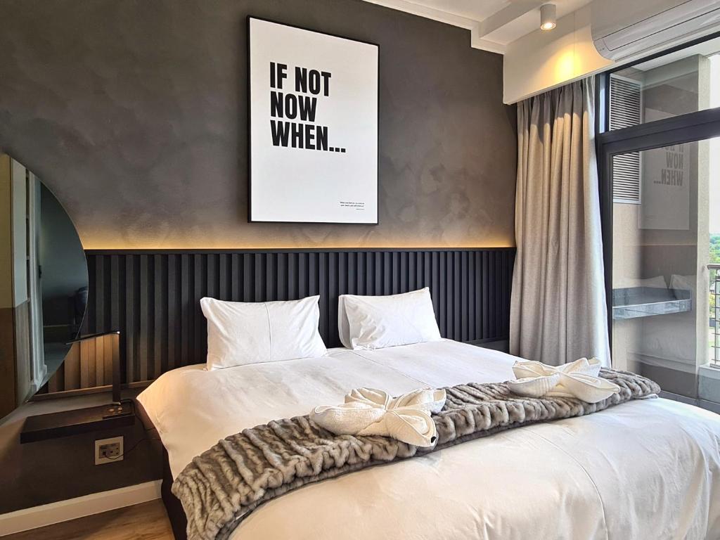 比勒陀利亚11 Floors in the Sky - Luxurious 1 Bedroom的一间卧室,配有一张床,床上有一个弓