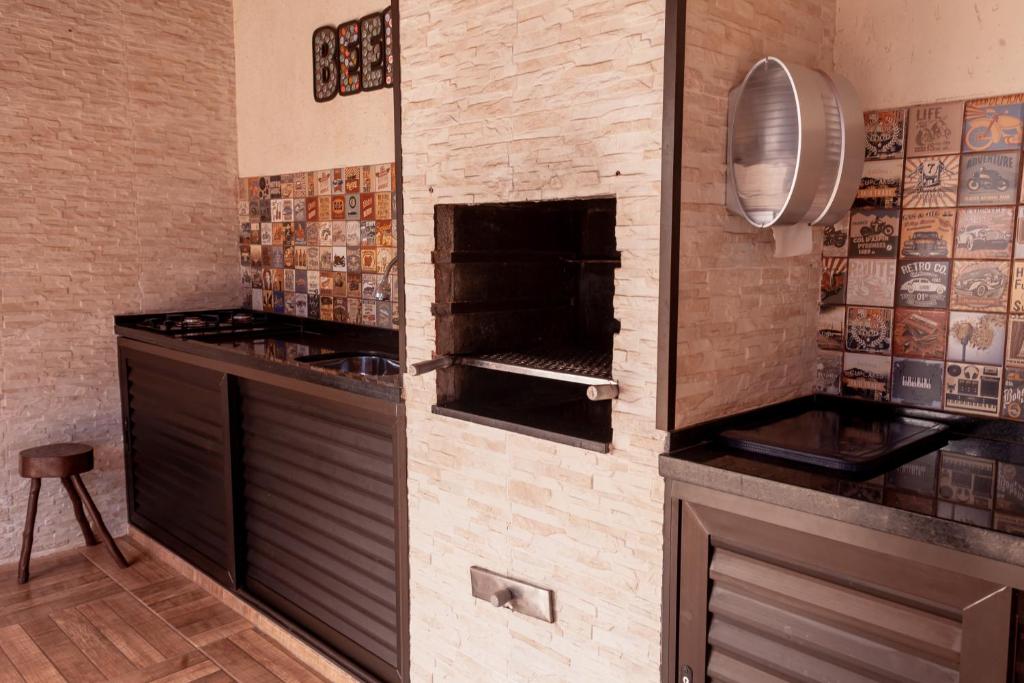 瓜鲁雅Pousada Canto Azul Guarujá的厨房设有带烤箱的砖墙