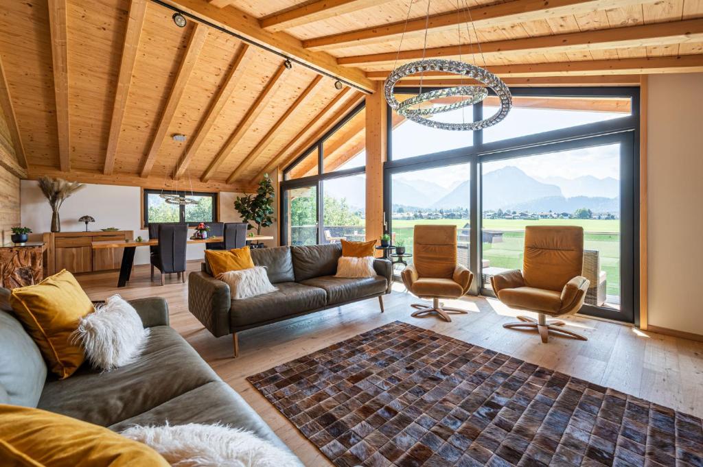 奥伯斯特多夫Alpine Lifestyle Lodge的带沙发和椅子的客厅以及大窗户。