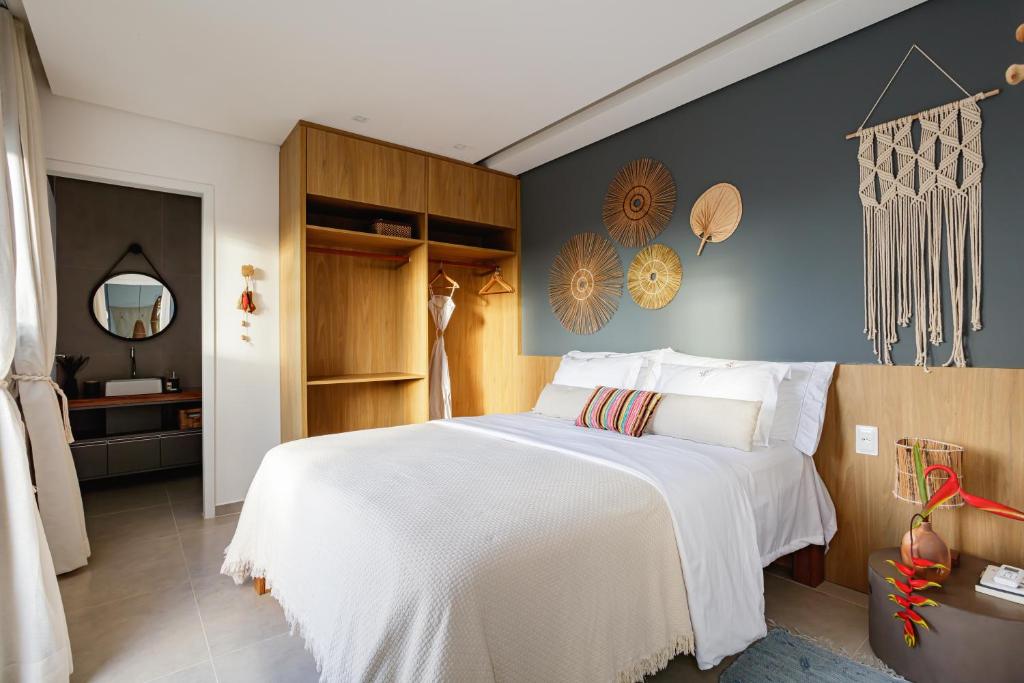 雅帕拉廷加VILA PITHAYA - Casa Jambo Rosa的卧室配有一张白色大床和镜子
