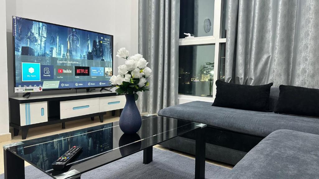 阿吉曼2 bedrooms new brand with amazing view的一间带电视和花瓶的客厅