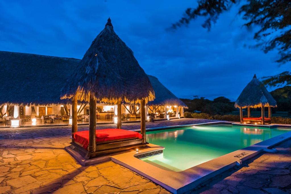 波波约Hotel Punta Teonoste的一个带床和茅草伞的度假游泳池