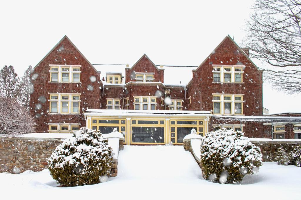 曼切斯特威尔伯顿旅馆的前方有灌木丛的积雪覆盖的建筑