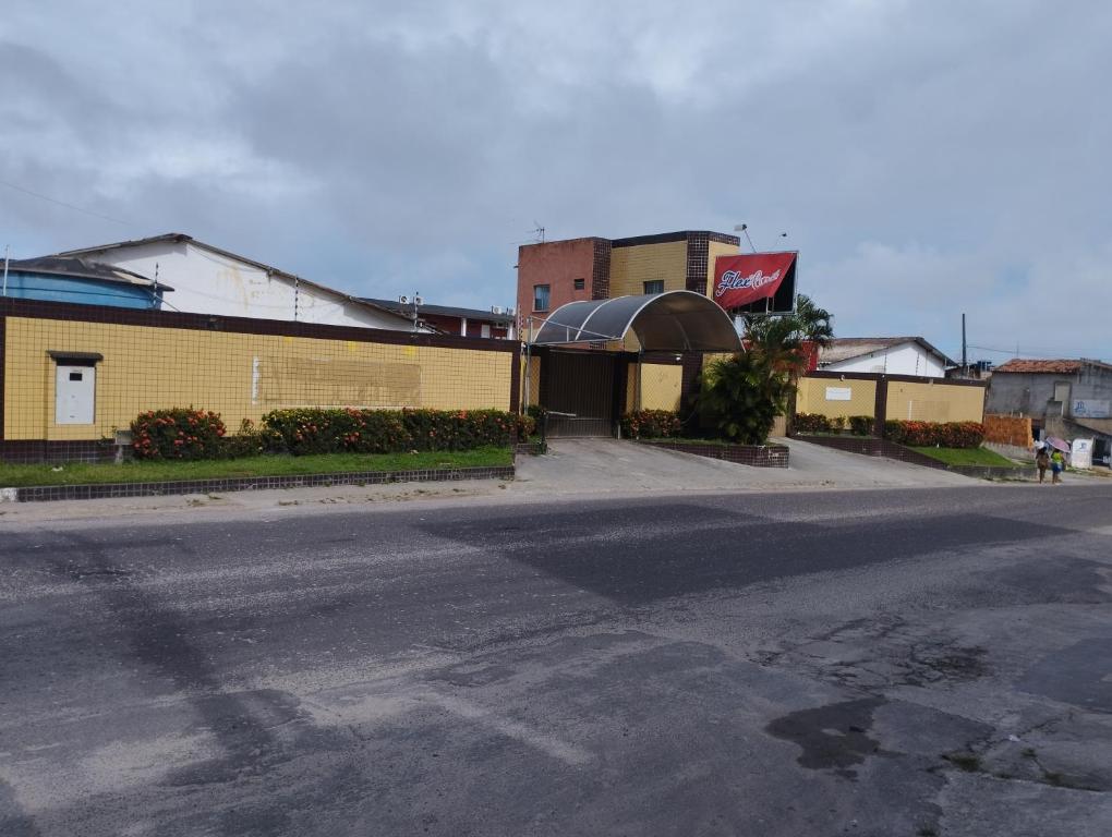 阿拉卡茹Motel FLEX LOVE LAMARAO的黄色建筑前的一条空街道