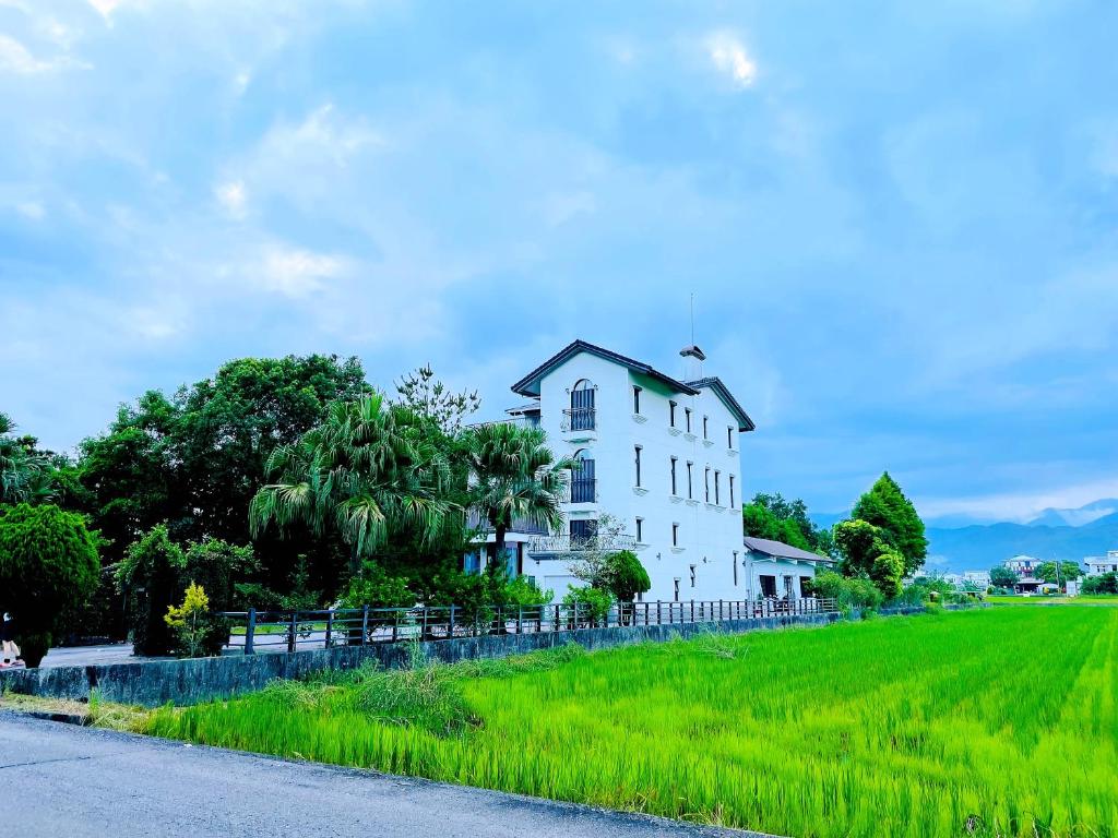 宜兰市兰天民宿的一座白色的房子,位于一座绿地小山上