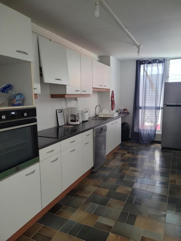 皮特尔角城Le 9ème étage du bonheur的厨房配有白色橱柜和瓷砖地板。