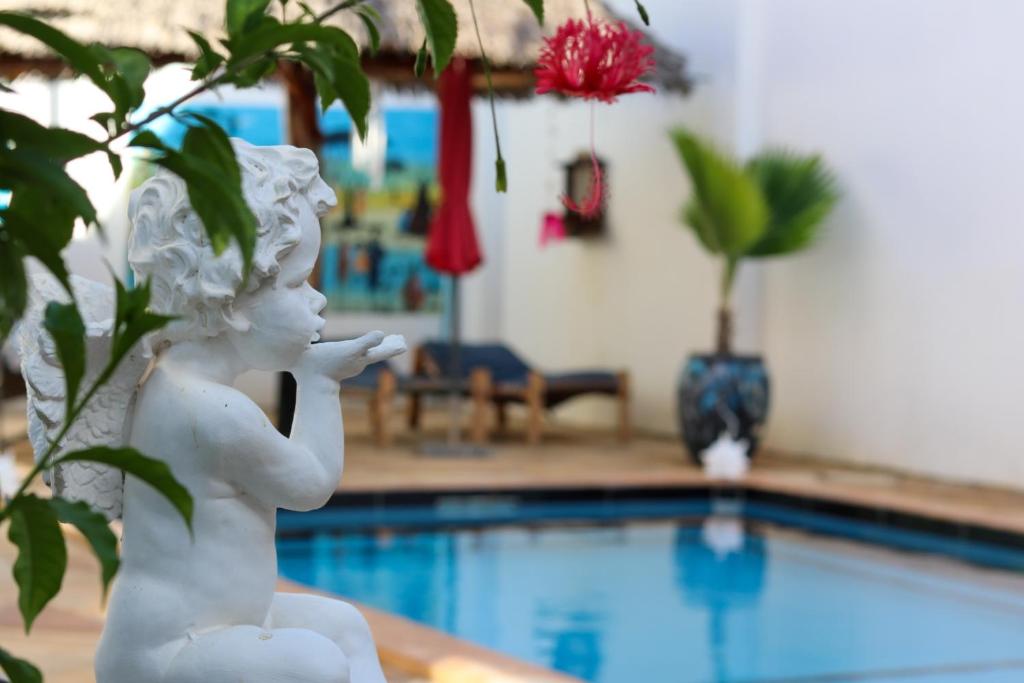 南威Daniel Zanzibar Hotel的坐在游泳池旁的女孩雕像