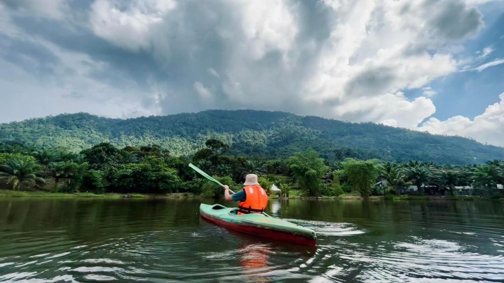 金宝Sahom Valley Resort - Agro & Eco Park的河上的人在皮划艇里