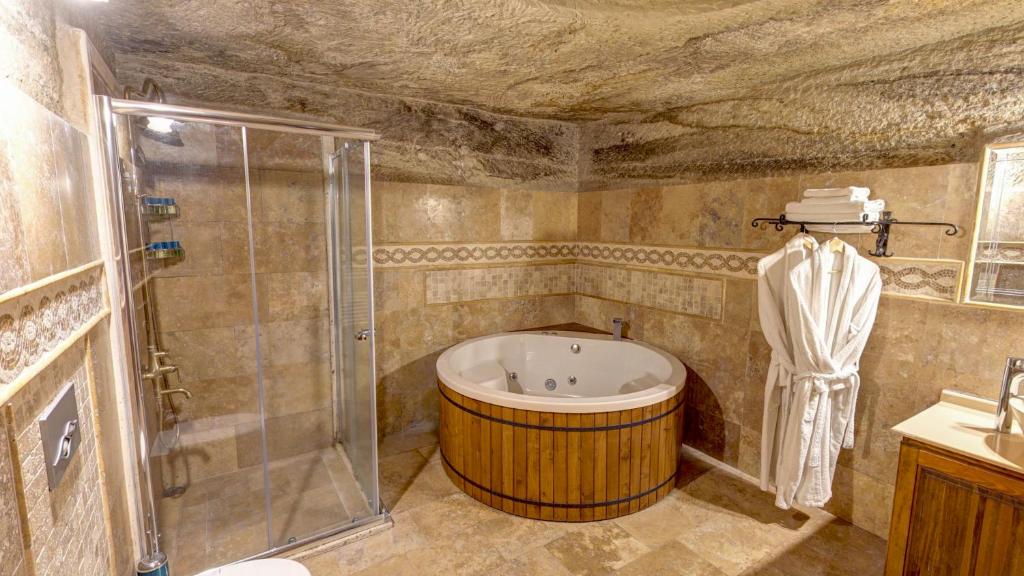 格雷梅Chelebi Cave House Hotel Over 6的一间带大浴缸和淋浴的浴室