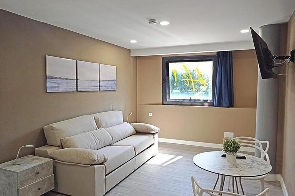马里亚诺Apartamentos Hi Apartaments Santander 3000的客厅配有沙发和桌子