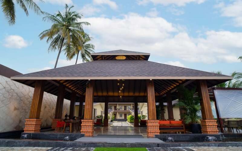 瓦伊Gandharv Resorts的一个带棕榈树和建筑的凉亭