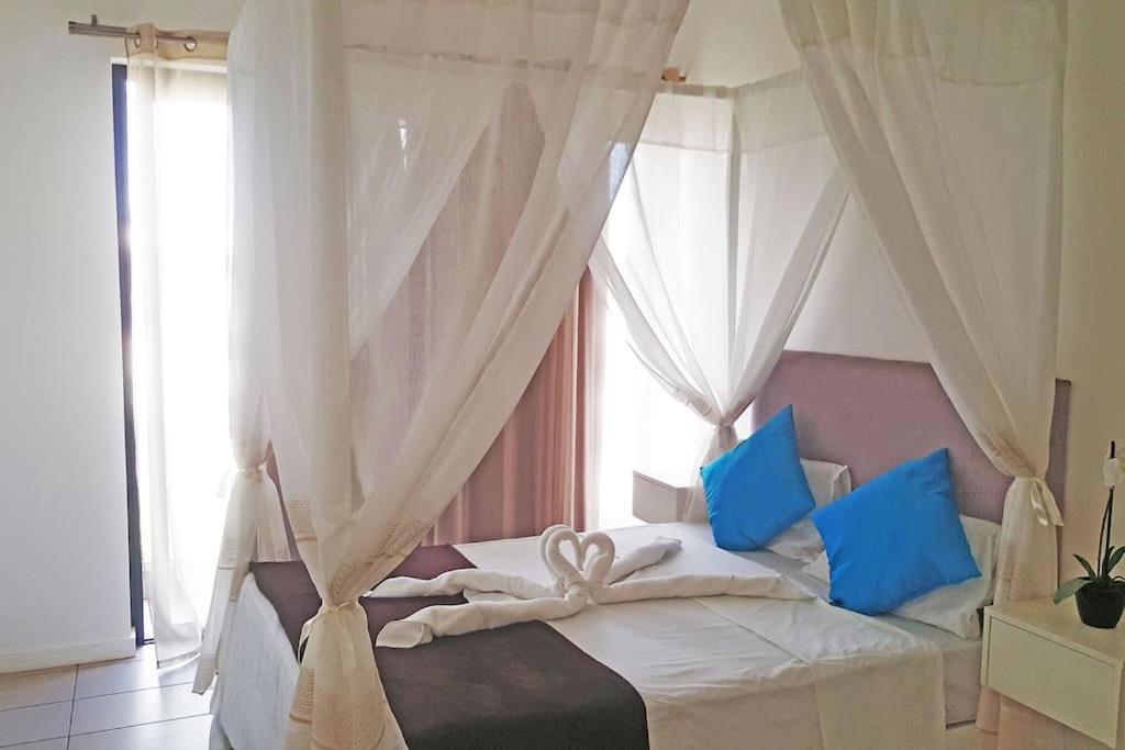 罗驰诺尔Lovely 3-bedroom at Azuri Ocean & Golf village的一间卧室配有白色床和蓝色枕头