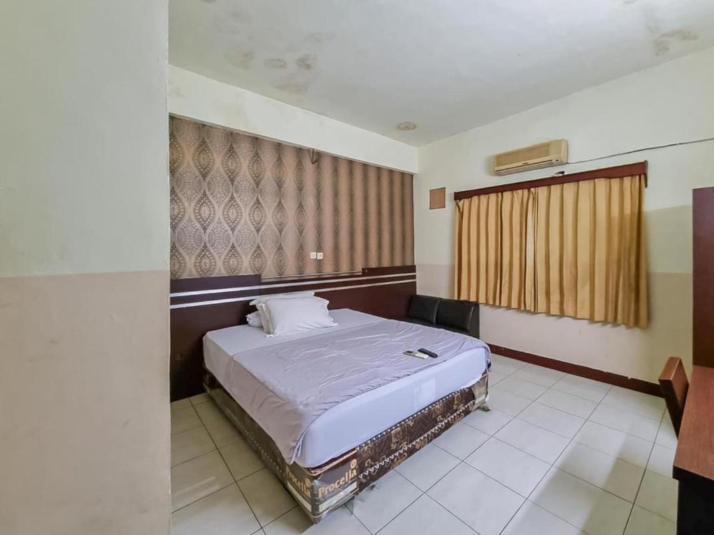 帕朗卡拉亚Hotel Halmahera Palangkaraya Mitra RedDoorz的一间卧室,卧室内配有一张大床