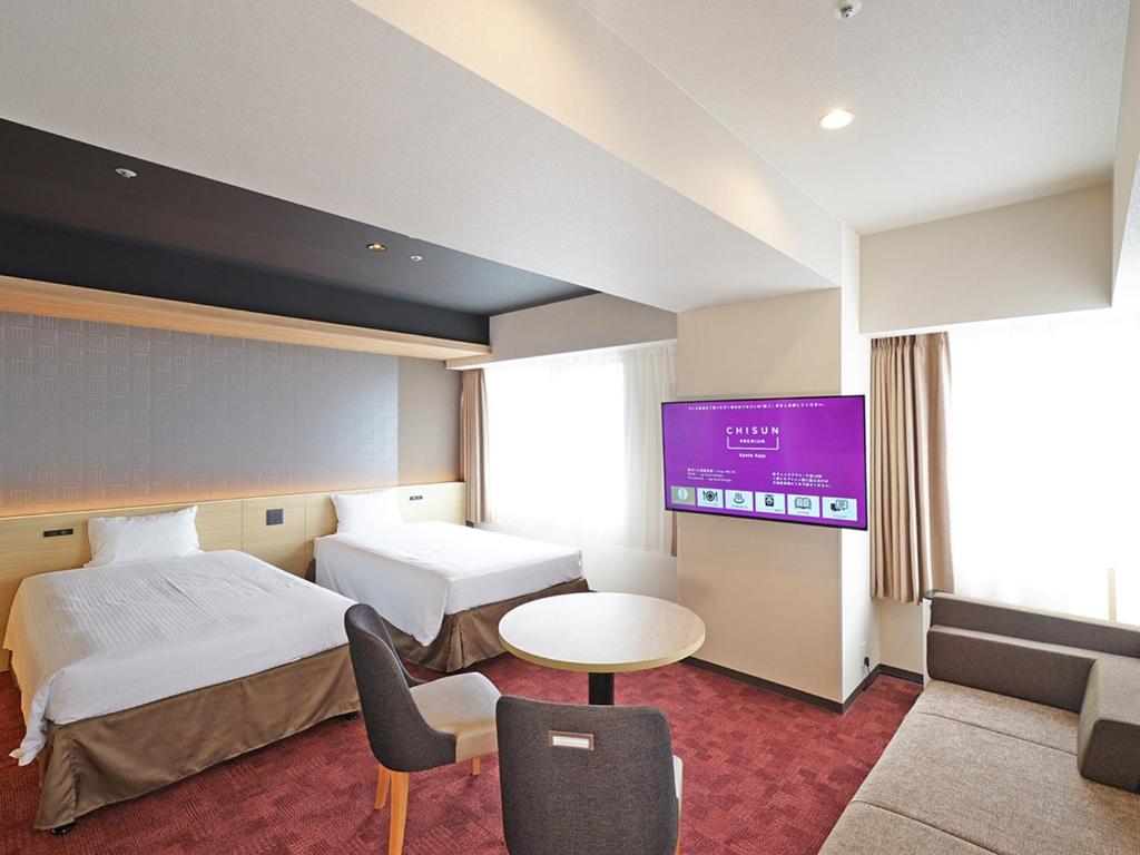 京都CHISUN PREMIUM Kyoto Kujo的酒店客房设有两张床和一台平面电视。