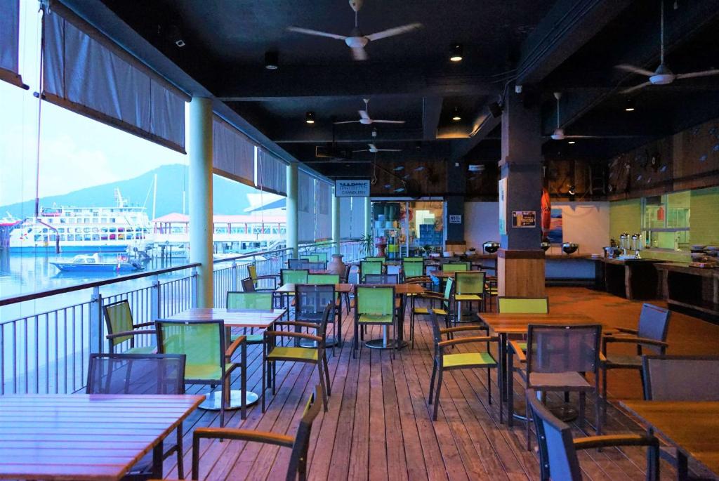 瓜埠Ramada by Wyndham Langkawi Marina的一间设有桌椅的餐厅,享有船舶美景