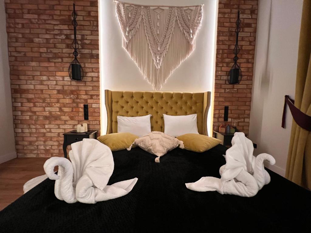 弗罗茨瓦夫Brick Castle - Apartament Helga的一间卧室配有一张带两个天鹅的床